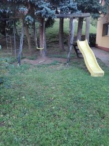 ペーチにあるForest Apartmannの庭の遊び場の黄色い滑り台