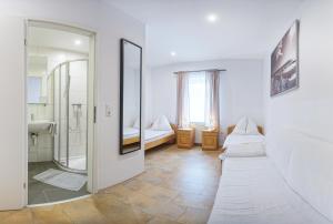 ein Badezimmer mit Dusche, Waschbecken und Spiegel in der Unterkunft Gösserhof in Leoben