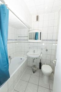 een badkamer met een wastafel, een bad en een toilet bij City Hotel Wuppertal in Wuppertal