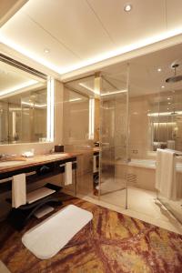 
a large bathroom with a large tub and a large mirror at The Okura Prestige Taipei in Taipei
