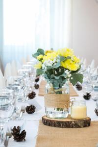 uma mesa com um vaso de flores amarelas em Hotel CITY em Prnjavor