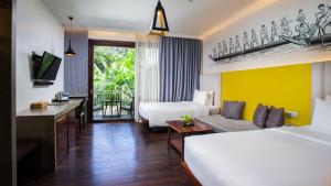 a hotel room with two beds and a desk at Apsara Residence Hotel in Siem Reap