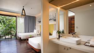a bathroom with a sink and a bedroom with a bed at Apsara Residence Hotel in Siem Reap