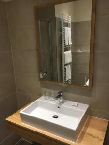 a bathroom with a white sink and a mirror at Hotel Restaurant Am Kring in Vreden +70 photos