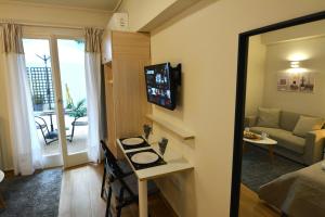 a living room with a table and a television in a room at Studio Posh with garden in Kolonaki in Athens