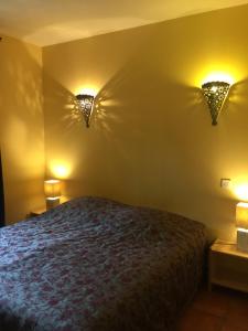カルパントラにあるLes Bastidons d'Angèleのベッドルーム1室(ベッド1台、壁に照明2つ付)