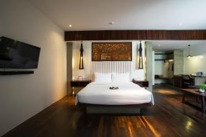 a bedroom with a white bed and a flat screen tv at Apsara Residence Hotel in Siem Reap