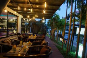 a restaurant with tables and chairs and palm trees at Apsara Residence Hotel in Siem Reap