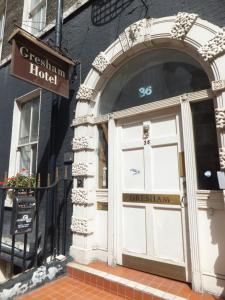 un edificio con una puerta blanca con un letrero encima en Gresham Hotel Bloomsbury, en Londres