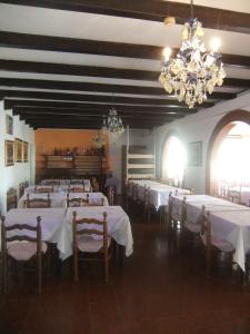 een eetkamer met witte tafels en stoelen en kroonluchters bij Hotel Da Bepi in Lido di Jesolo