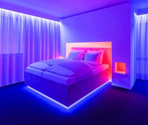 a purple bedroom with a large bed with pink pillows at smartel at The Unbrexit in Ahaus