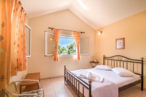 a bedroom with a bed and a window at Villa Iliogenniti in Kalamaki
