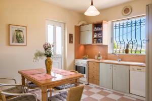 a kitchen with a table with a vase of flowers on it at Villa Iliogenniti in Kalamaki