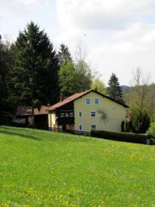 une maison blanche avec un tableau sur son côté dans l'établissement Haus am Wald, à Bad Kötzting