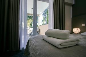 a bed with a pile of towels on top of it at Sundial Boutique Hotel in Zagreb