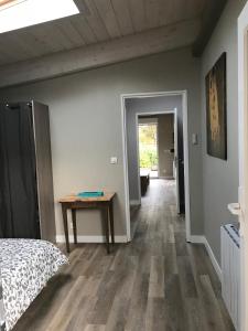 a bedroom with a bed and a table in it at Les Terrasses de La Malcombe in Besançon