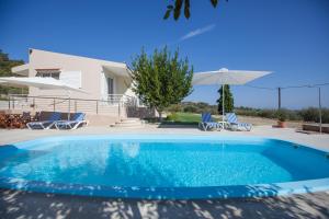 a swimming pool in front of a villa at The Olive Grove Villa Private Pool with star links WiFi in Theologos