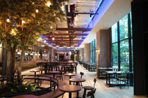 Orakai Cheonggyesan Hotel في سول: مطعم بطاولات وكراسي ونوافذ كبيرة