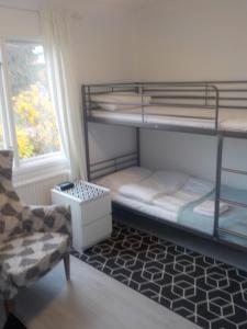 um quarto com beliches, uma cadeira e uma janela em Hagfors Hostel em Råda