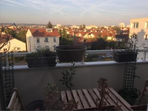 a balcony with potted plants and a view of a city at Appartement T2 - Proche RER in Sartrouville