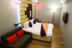 1 dormitorio con cama, sofá y TV en Le Dream Boutique Hotel en George Town