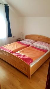 un grande letto in legno in una camera da letto con pavimento in legno di Villa Rose a Veľký Meder