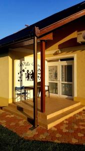 a house with a deck with a table on it at Villa Rose in Veľký Meder