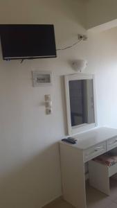 a bathroom with a television and a sink at Sunbeam in Agios Nikolaos