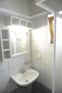 a white bathroom with a sink and a mirror at Sunbeam in Agios Nikolaos