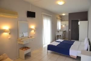 a hotel room with a bed and a tv at Sunbeam in Agios Nikolaos