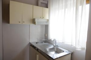 Elle comprend une petite cuisine avec un évier et une fenêtre. dans l'établissement Sunbeam, à Agios Nikolaos