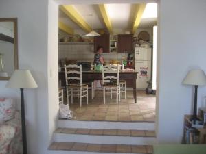 una persona en una cocina con mesa y sillas en 28 Rue de la Ferrage, en Fayence