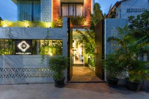 an entrance to a building with plants in front of it at Monthara Angkor Residence in Siem Reap