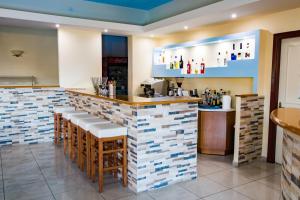 un restaurante con un bar con azulejos blancos y azules en Kyra Panagia Hotel, en Kyra Panagia