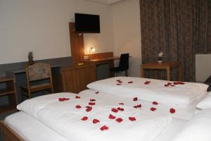 una camera con due letti con rose rosse sopra di Dolomitenhotel Lienz a Lienz