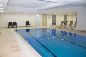 a large swimming pool with chairs in a room at ZİN D Home Dudullu Suit Otel in Istanbul