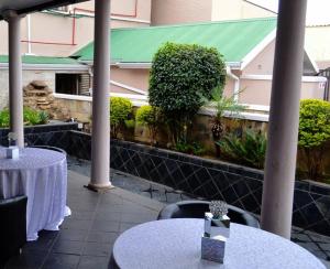 eine Terrasse mit Tischen und Stühlen und ein Gebäude in der Unterkunft Crown Hotel in Ladysmith