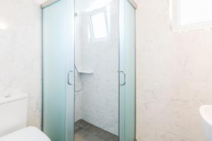 a glass shower door in a bathroom with a toilet at Panorama Apartments updated with infinity pool in Agios Nikolaos