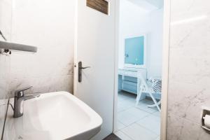 a white bathroom with a sink and a desk at Panorama Apartments updated with infinity pool in Agios Nikolaos