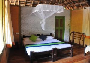 a bedroom with a bed with a mosquito net at Back of Beyond - Wild Haven in Sigiriya