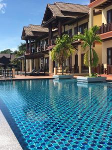 a swimming pool in front of a villa at Pon Arena Hotel in Muang Không