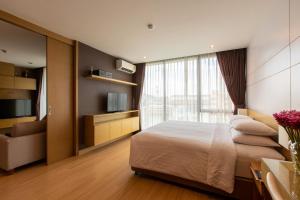 a bedroom with a large bed and a television at Sanae' Hotel Chiang Mai in Chiang Mai