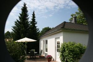 レヒリンにあるFerienhaus Nachtigallの小さな白い家(テーブル、傘付)