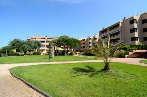 a park with a palm tree in front of a building at Golf Mar II G 1-2 in Pals