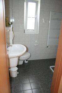 Baño blanco con lavabo y aseo en Ferienhaus Nachtigall, en Rechlin