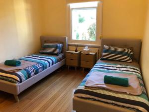 twee bedden in een kleine kamer met een raam bij Riverbank villa in Devonport