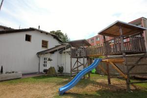 a playground with a blue slide in a yard at Penzion Olga in Mariánské Lázně