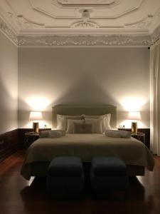 a bedroom with a large bed with two lamps at Oryza Guest House& Suites in Coimbra