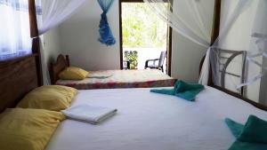 a bedroom with two beds and a window at New Chili Lodge Mirissa in Mirissa