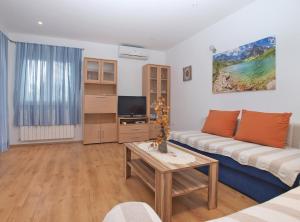 sala de estar con sofá y TV en Apartments 1282, en Fažana
